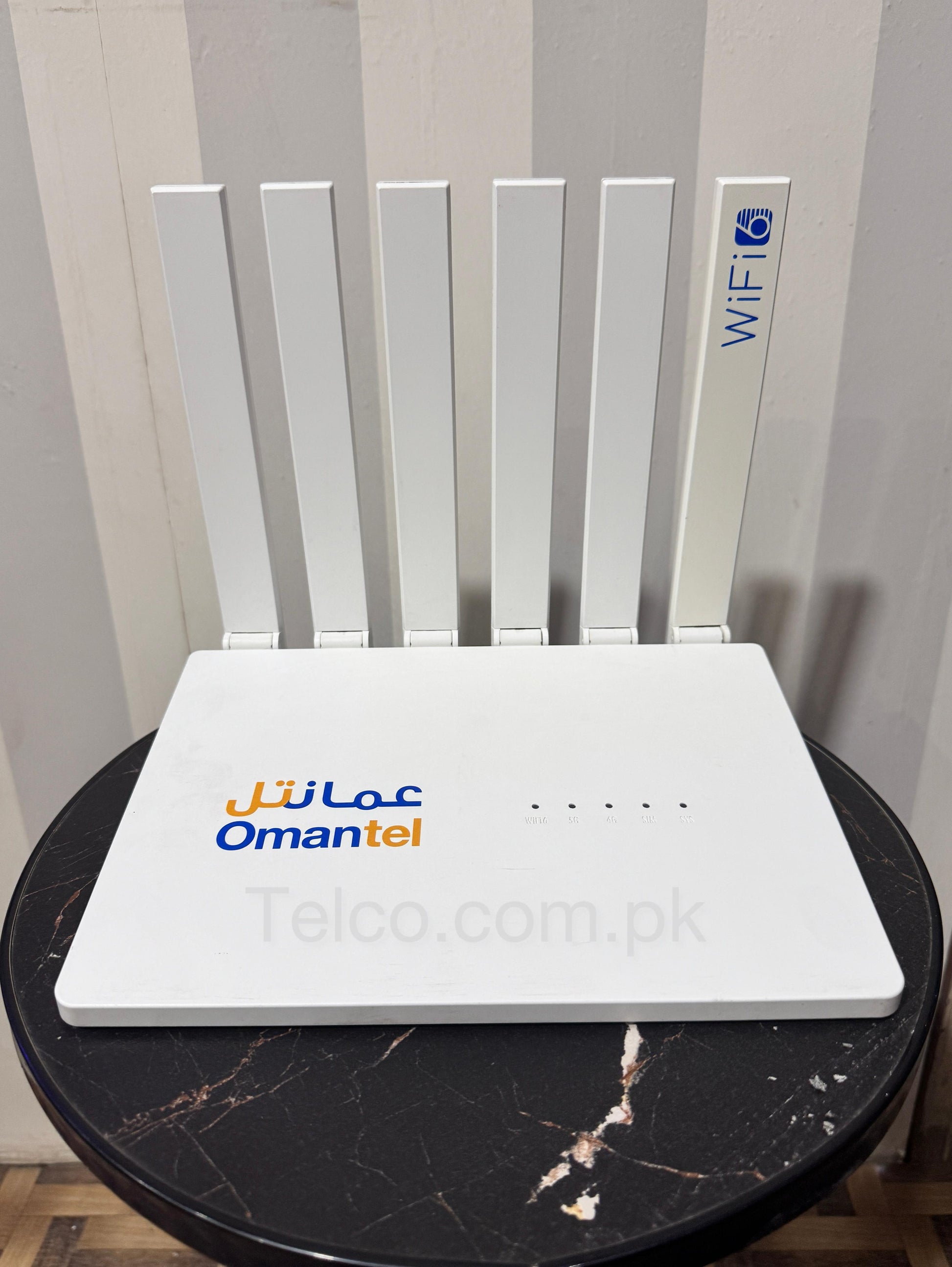 A white Greenpacket 5G SIM router with six external antennas, a branded display screen, and multiple ports for networking.