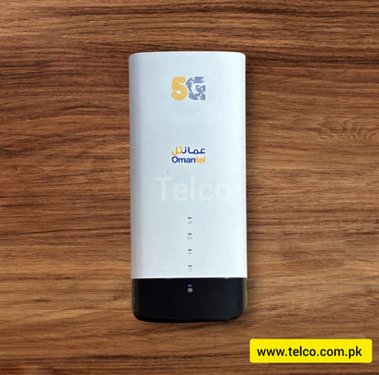 A white 5G mobile router with the branding 'OmanTel' on the front, placed on a wooden surface.