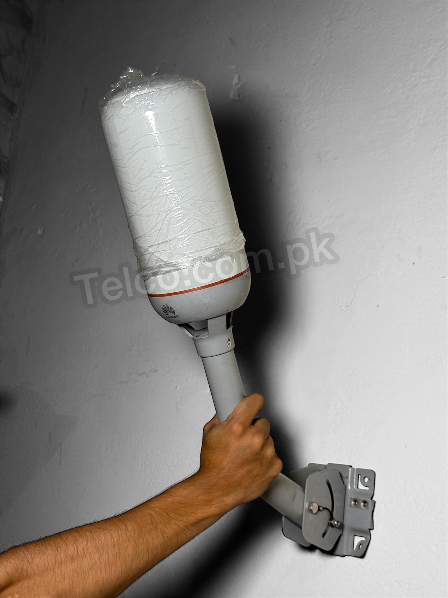 Person using a paint roller to apply white paint on a wall.