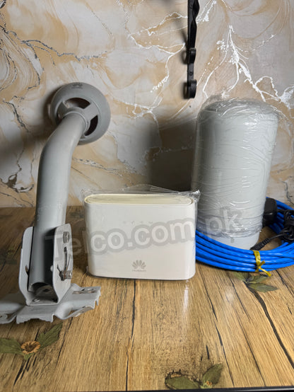 White device with blue cable on a wooden surface against a marble wall.